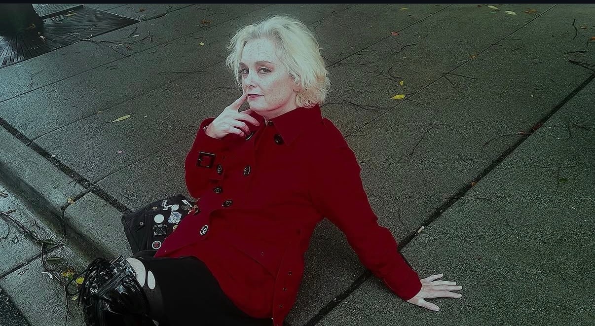 Woman in red coat holding vintage camera